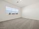 This bedroom features large window, neutral carpet and light colored walls at 17624 W Pierson St, Goodyear, AZ 85395