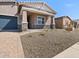 Landscaped front yard leads to a charming single-story home with stone accents and a covered entry at 17624 W Pierson St, Goodyear, AZ 85395