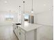 Bright kitchen features a large island, sleek countertops, stylish pendant lighting, and modern fixtures at 17624 W Pierson St, Goodyear, AZ 85395