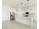 Modern kitchen boasts stainless steel appliances, white cabinetry, a spacious island, and elegant pendant lights at 17624 W Pierson St, Goodyear, AZ 85395