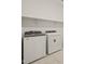 The laundry room features new Whirlpool washer and dryer and built-in shelving for storage and organization at 17624 W Pierson St, Goodyear, AZ 85395
