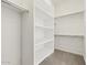 Well-organized walk-in closet with custom shelving and ample hanging space provides practical storage solutions at 17624 W Pierson St, Goodyear, AZ 85395