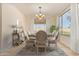 Virtually staged dining room with elegant lighting, a table set for six, and large windows at 1870 E Indigo Dr, Chandler, AZ 85286