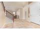 Spacious foyer featuring tile floors, a staircase with wood railings, and a view into the living area at 1870 E Indigo Dr, Chandler, AZ 85286