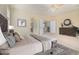 Staged main bedroom with a wooden bed frame, carpet, ceiling fan, and accent furniture at 1870 E Indigo Dr, Chandler, AZ 85286