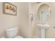 Cozy powder room features a pedestal sink, round mirror, and neutral decor at 1870 E Indigo Dr, Chandler, AZ 85286