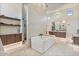 Luxurious bathroom with a soaking tub, floating shelves, and a dual-sink vanity with modern fixtures at 19726 E Vallejo St, Queen Creek, AZ 85142