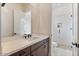 Bright bathroom featuring a large mirror and vanity, with a view of the shower at 19726 E Vallejo St, Queen Creek, AZ 85142