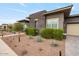Striking exterior featuring a combination of modern materials, professional landscaping, and a well-lit driveway at 19726 E Vallejo St, Queen Creek, AZ 85142