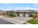 The modern home boasts a desert-style landscape, a three-car garage and an extended driveway at 19726 E Vallejo St, Queen Creek, AZ 85142