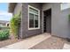 Modern home exterior with stone accents, lush landscaping, and a welcoming entrance at 19726 E Vallejo St, Queen Creek, AZ 85142