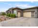 Side view of the home highlighting the three-car garage, sleek design, and manicured desert landscaping at 19726 E Vallejo St, Queen Creek, AZ 85142