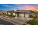 Angle shot of the house highlighting the three-car garage, desert landscaping, and modern architectural details at 19726 E Vallejo St, Queen Creek, AZ 85142