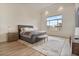 Serene main bedroom with light wood floors, large window and accent rug at 19726 E Vallejo St, Queen Creek, AZ 85142
