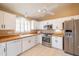 Bright kitchen features white cabinetry, stainless steel appliances, and tile countertops at 20027 N 110Th Ln, Peoria, AZ 85373