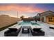 Twilight view of a backyard pool with a waterfall feature, spa, and lounge chairs at 22421 N 34Th St, Phoenix, AZ 85050