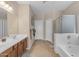 Bright bathroom with double sinks, soaking tub, and neutral tile flooring at 2635 W Angel Way, San Tan Valley, AZ 85144