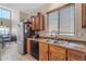Kitchen featuring a stainless steel refrigerator, dual basin sink, and wood cabinets at 2635 W Angel Way, San Tan Valley, AZ 85144