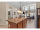 Stylish kitchen island featuring wood cabinetry and tile flooring open to the dining and living room at 2635 W Angel Way, San Tan Valley, AZ 85144