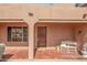 Covered front porch featuring a dark wooden door, seating, and a delightful fountain at 28907 N 225Th Ave, Wittmann, AZ 85361