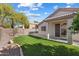 Inviting backyard featuring green artificial turf, landscaping, and a covered patio with sliding glass door access at 30420 N 43Rd St, Cave Creek, AZ 85331