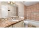 Tiled bathroom with a decorative countertop, single sink, bathtub and shower combo at 3135 W Echo Ln, Phoenix, AZ 85051