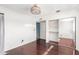 Bright bedroom with white walls, wood floors, and a mirrored closet adds classic charm at 3135 W Echo Ln, Phoenix, AZ 85051