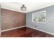 Cozy bedroom featuring a brick accent wall and a window letting in natural light at 3135 W Echo Ln, Phoenix, AZ 85051