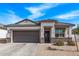 Charming single-story home featuring a stone-accented facade, gray trim, and a two-car garage at 4051 S 243Rd Dr, Buckeye, AZ 85326