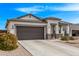 Attractive one-story home showcasing neutral stucco, stone accents, and a spacious driveway at 4051 S 243Rd Dr, Buckeye, AZ 85326