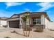 Beautifully landscaped single-story home with gray stone accents, a two-car garage, and manicured front yard at 4051 S 243Rd Dr, Buckeye, AZ 85326