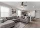 Cozy living room featuring a large sectional sofa, ceiling fan, and view into the kitchen at 4051 S 243Rd Dr, Buckeye, AZ 85326