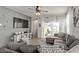 Comfortable living room highlighting a stylish gray sectional sofa, a large TV, and tiled floors at 4051 S 243Rd Dr, Buckeye, AZ 85326