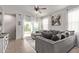 Bright living room showcasing a spacious gray sofa, tiled floors, and sliding door access to the yard at 4051 S 243Rd Dr, Buckeye, AZ 85326