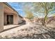 This backyard features desert landscaping, a covered patio, a stone pathway, and a private, fenced-in yard at 41309 N Belfair Way, Anthem, AZ 85086