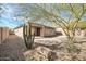 Charming backyard featuring a desert landscape, stone accents, and covered patio for outdoor relaxation at 41309 N Belfair Way, Anthem, AZ 85086