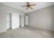 Large bedroom with a ceiling fan, carpet flooring, and closet with sliding doors at 41309 N Belfair Way, Anthem, AZ 85086