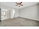 This carpeted bedroom has a ceiling fan and an open doorway leading to other rooms at 41309 N Belfair Way, Anthem, AZ 85086