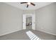 This carpeted bedroom features a ceiling fan and doorway leading to another room at 41309 N Belfair Way, Anthem, AZ 85086