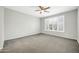 A bedroom with carpet, plantation shutters on a window, and neutral paint at 41309 N Belfair Way, Anthem, AZ 85086