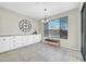 Dining area with large window, decorative wall clock, granite countertops, and built-in white cabinets at 41309 N Belfair Way, Anthem, AZ 85086