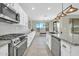 Modern kitchen with stainless steel appliances, white cabinets, granite countertops, and a view to the outdoors at 41309 N Belfair Way, Anthem, AZ 85086