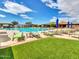 Resort-style pool with multiple lounge chairs and umbrellas surrounded by well-maintained grass at 41309 N Belfair Way, Anthem, AZ 85086