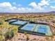 Aerial view of well-maintained tennis courts with players amid desert scenery at 41309 N Belfair Way, Anthem, AZ 85086