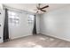 An unfurnished bedroom with a ceiling fan, two large windows and neutral decor at 434 E Rosemonte Dr, Phoenix, AZ 85024