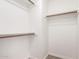 An empty walk-in closet with white walls and baseboards and natural wood shelving at 434 E Rosemonte Dr, Phoenix, AZ 85024