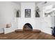 Close-up of the white fireplace in the living room, accented with decor and hardwood floors at 4901 W Beverly Ln, Glendale, AZ 85306