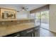 Breakfast bar with granite counters separates kitchen from outdoor patio access at 4950 N Miller Rd # 135, Scottsdale, AZ 85251