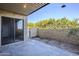 Outdoor patio area features stone pavers, sliding glass doors, and a private wall for seclusion at 4950 N Miller Rd # 135, Scottsdale, AZ 85251