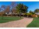 Inviting front exterior featuring a circular driveway, lush lawn and mature shade trees at 5546 N 4Th St, Phoenix, AZ 85012